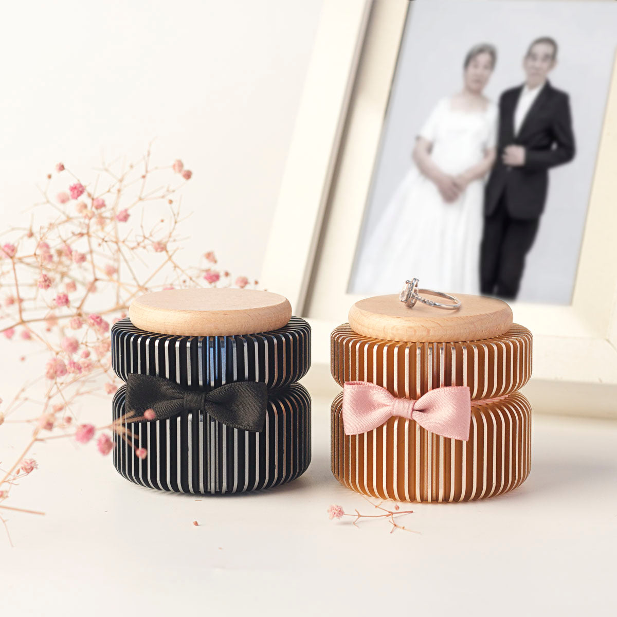 Two personalized keepsake urns for couple or parents – rose gold and dark gray side by side, with family photo background