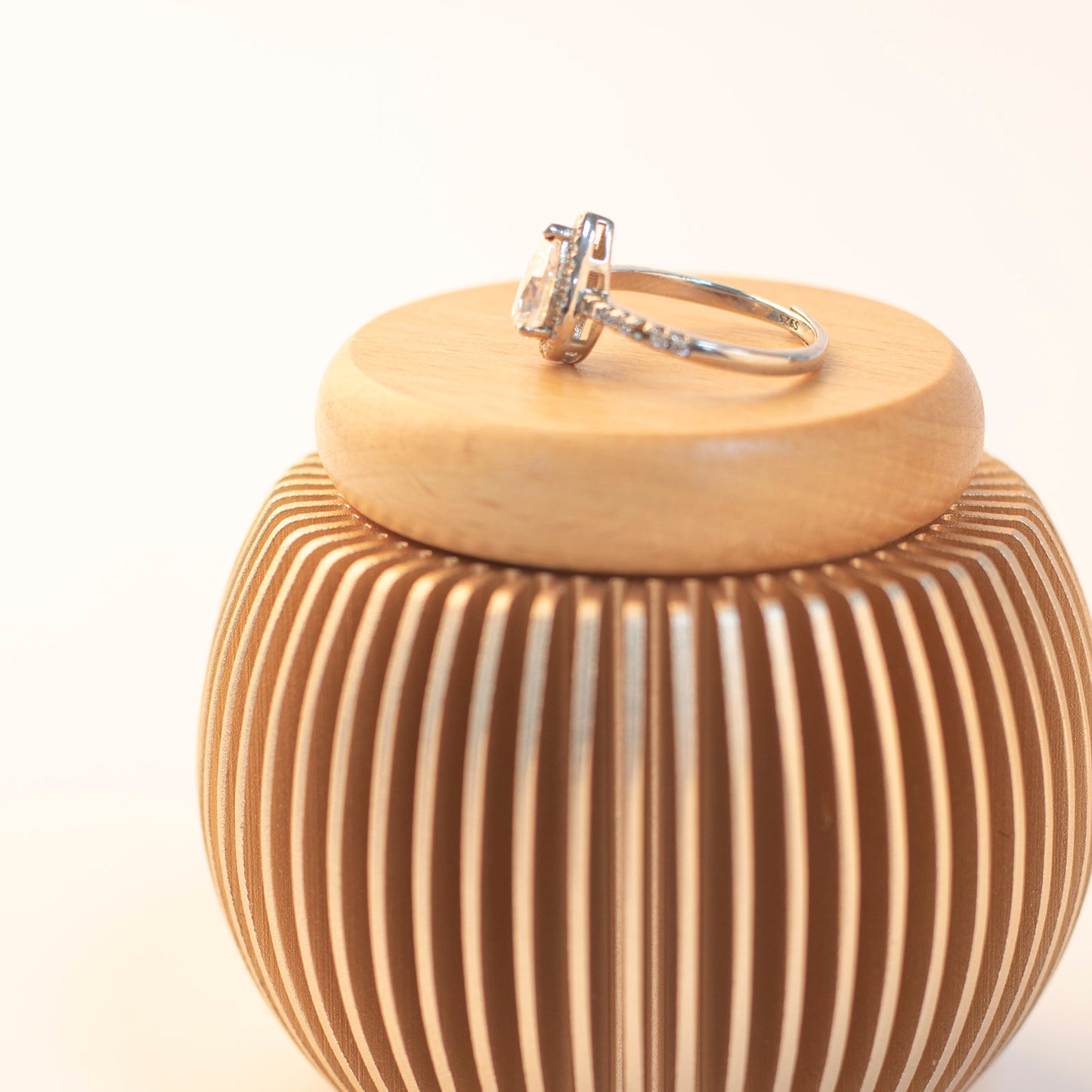 Rose gold keepsake urn with beech wood lid – holds small mementos like a ring on top, perfect for personal memorial display
