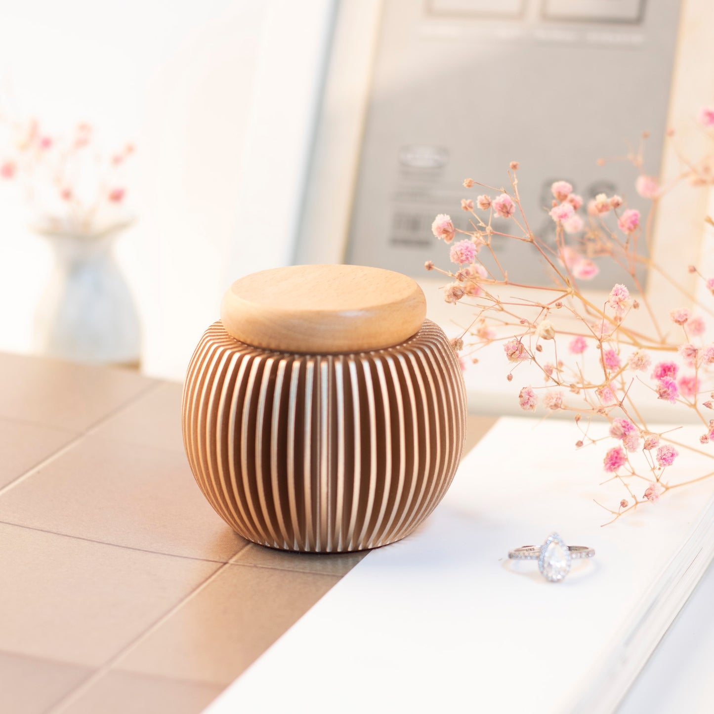 Rose gold egg-shaped keepsake urn on table – elegant home decor with dried flowers, warm and peaceful memorial display