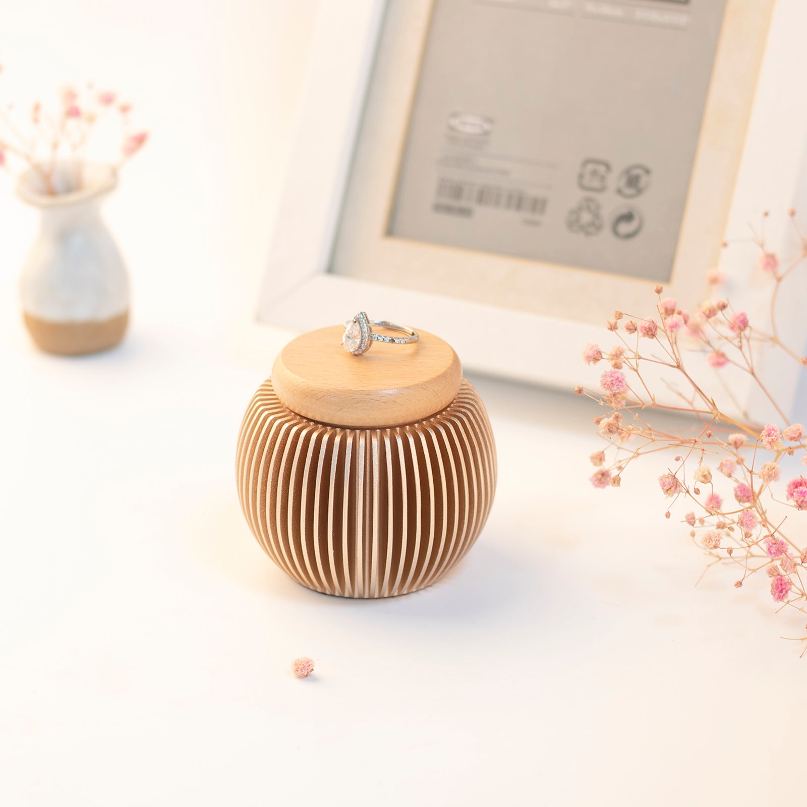 Rose gold keepsake urn with ring on beech wood lid – surrounded by photo frame, vase and dried flowers, complete memorial display