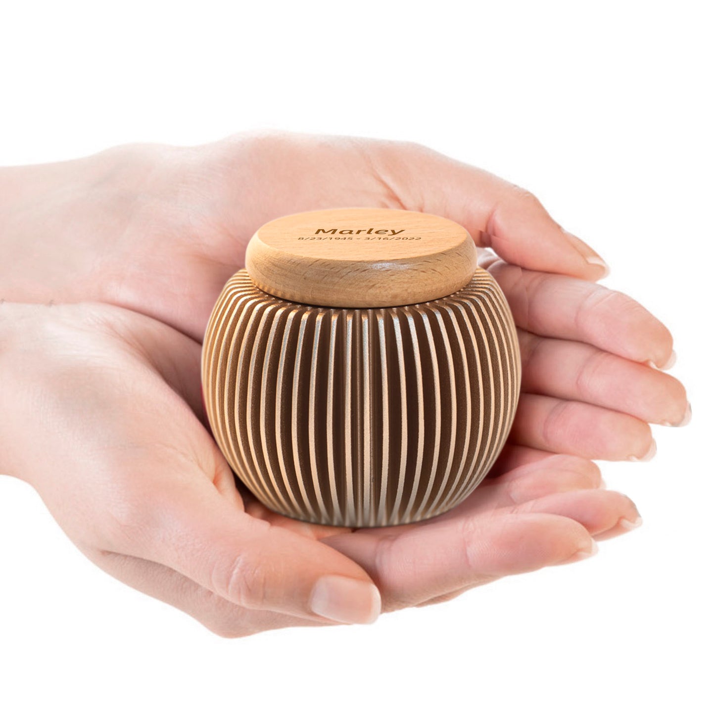 Custom engraved keepsake urn held in hands – egg-shaped aluminum & beech wood